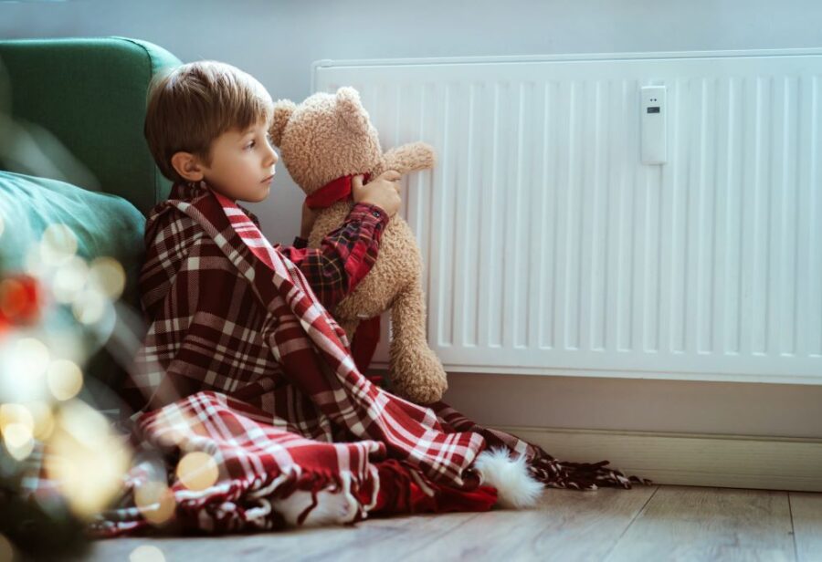 Quelles solutions de chauffage privilégier dans une chambre d’enfant ? Enfant jouant avec une peluche près d'un radiateur dans sa chambre
