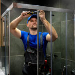 Technicien installant une paroi de douche en verre
