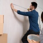 Couple préparant l’installation d’un papier peint dans leur logement